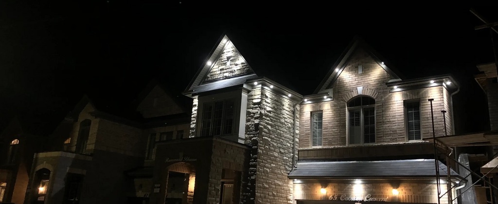 Soffit pot lights on a home exterior at night